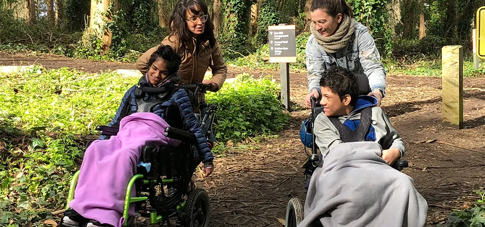 Two visitors in wheelchairs hiking